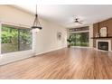 Spacious living room featuring fireplace, ceiling fan, and laminate wood flooring at 4135 E Altadena Ave, Phoenix, AZ 85028