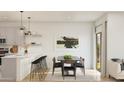Bright dining area adjacent to the kitchen with modern pendant lighting and neutral decor for a comfortable feel at 42515 W Peters Dr, Maricopa, AZ 85138