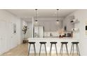 Open-concept kitchen featuring stainless steel appliances, a breakfast bar, and modern pendant lighting at 42515 W Peters Dr, Maricopa, AZ 85138