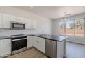 Kitchen with stainless steel appliances, white cabinetry, and granite counters at 5434 W T Ryan Ln, Laveen, AZ 85339