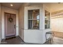 Inviting front porch featuring a decorative door and a cozy corner seating area with large windows for abundant natural light at 6846 S 26Th Pl, Phoenix, AZ 85042