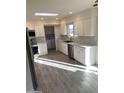Bright kitchen with stainless steel appliances, white cabinets, tiled backsplash, and wood-look tile flooring at 10025 W Shasta W Dr, Sun City, AZ 85351