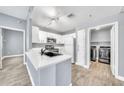 Open kitchen features white cabinets, quartz countertops, stainless steel appliances and adjacent laundry room at 11375 E Sahuaro Dr # 1008, Scottsdale, AZ 85259