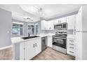 Bright updated kitchen with white cabinets, quartz countertops, stainless appliances and a view from the large window at 11375 E Sahuaro Dr # 1008, Scottsdale, AZ 85259