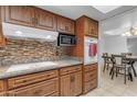 Cozy kitchen featuring wooden cabinetry, modern appliances, and a stylish tile backsplash at 12029 N 44Th Dr, Glendale, AZ 85304