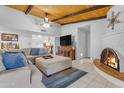 Inviting living room boasts wood-beamed ceilings, a stone fireplace, and neutral decor at 12029 N 44Th Dr, Glendale, AZ 85304