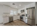 Modern kitchen featuring stainless steel appliances, white cabinets, and ample counter space at 16421 N 34Th Ave, Phoenix, AZ 85053