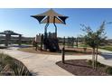 Community playground with shade structure and surrounding sidewalks at 17758 W Odeum Ln, Goodyear, AZ 85338