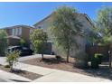 A beautiful home exterior featuring desert landscaping, mature shade trees and a brick paver driveway at 18400 W Ipswitch Way, Surprise, AZ 85374