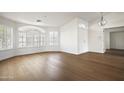 Spacious living room with wood floors, arched windows, and modern white shutters at 18873 N 94Th Way, Scottsdale, AZ 85255