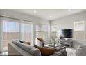 Bright living room with large windows, sliding glass door, and contemporary furnishings for relaxing and entertaining at 2317 S 125Th Dr, Avondale, AZ 85323