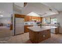 Well-lit kitchen featuring wood cabinetry, a center island with counter space, and views into the adjacent living space at 3227 W Kristal Way, Phoenix, AZ 85027
