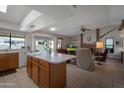 Open-concept living space with a large kitchen island, brick fireplace, and comfortable seating area with views of the exterior at 3227 W Kristal Way, Phoenix, AZ 85027