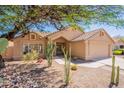 Tan home exterior showcases desert landscaping with drought-tolerant plants, cacti, and rock accents at 4037 E Milton Dr, Cave Creek, AZ 85331