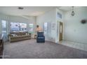 Inviting living room with large windows, neutral carpet, and comfortable seating at 5596 W Mercer Ln, Glendale, AZ 85304