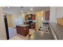 A well-lit kitchen boasts an island and dark countertops at 6908 S 54Th Ln, Laveen, AZ 85339
