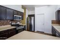 Well-equipped kitchen with stainless steel appliances, tile backsplash, and light countertops at 909 E Harwell Rd, Phoenix, AZ 85042