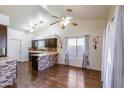 Bright living room featuring an open floor plan with wood floors, a ceiling fan, and a kitchen view at 909 E Harwell Rd, Phoenix, AZ 85042