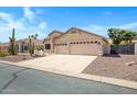 Attractive single-story residence featuring desert landscaping and a spacious driveway leading to a three-car garage at 10214 E Moonshadow Way, Gold Canyon, AZ 85118