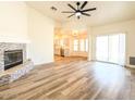 Open-concept living room features tile fireplace, wood floors, and kitchen views at 10722 W Quartz Dr, Casa Grande, AZ 85193