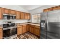 Well-lit kitchen with wood cabinets, stainless steel appliances, and modern flooring at 16333 W Paradise Ln, Surprise, AZ 85388