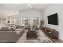 Bright living room featuring vaulted ceilings, neutral furniture, and stylish decor at 16333 W Paradise Ln, Surprise, AZ 85388