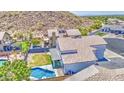 Aerial view showcasing a well-maintained backyard with a pool, lush lawn, and mountain views at 1853 N Rowen Cir, Mesa, AZ 85207