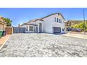 Two story home with a white exterior, desert landscaping, a two car garage and a gray brick driveway at 1853 N Rowen Cir, Mesa, AZ 85207