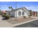 A single-story home with arched windows and desert landscaping is complemented by mature trees at 1881 E Kerby Farms Rd, Chandler, AZ 85249