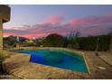 Relaxing backyard with a sparkling pool, brick patio, and desert landscaping, perfect for enjoying warm evenings at 1935 E Seminole Dr, Phoenix, AZ 85022