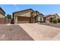 This charming one-story home showcases desert landscaping and a brick driveway leading to a two-car garage at 226 E Monza Way, San Tan Valley, AZ 85140