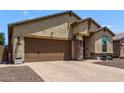 A single-story home featuring desert landscaping, a brick driveway, and a convenient two-car garage at 226 E Monza Way, San Tan Valley, AZ 85140