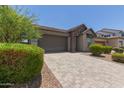 Attractive single-story house showcasing a paved driveway, a two-car garage, and well-maintained landscaping at 29007 N 120Th Dr, Peoria, AZ 85383