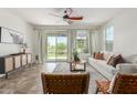 Inviting living room boasts a ceiling fan, tile floors, and sliding glass doors that bring the outdoors in at 29007 N 120Th Dr, Peoria, AZ 85383