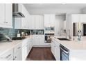 Bright kitchen with white cabinets, stainless steel appliances, and a sleek tile backsplash at 4615 E Navigator Ln, Phoenix, AZ 85050