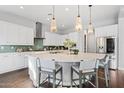 Bright kitchen with white cabinets, stainless steel appliances, and a large island with pendant lighting at 4615 E Navigator Ln, Phoenix, AZ 85050