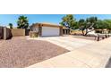 Home's driveway and two-car garage, complimented by a gravel front yard at 5302 W Poinsettia Dr, Glendale, AZ 85304