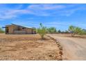 Wide view of a modern home featuring desert landscaping and a long gravel driveway with decorative rock border at 553 W Cavalry Rd, New River, AZ 85087