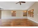 Spacious living room with wood floors, a ceiling fan and plenty of natural light at 5734 W Commonwealth Pl, Chandler, AZ 85226