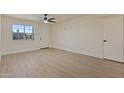 Bright living room with new flooring, ceiling fan, and a large window providing natural light at 7008 W Sierra St, Peoria, AZ 85345