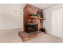 Cozy living room showcasing a rustic brick fireplace and a wooden mantel, enhancing the space's inviting charm at 8501 E Malcomb Dr, Scottsdale, AZ 85250