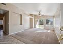 The open living room features neutral carpet, a ceiling fan, and a sliding door to the backyard at 9422 W Monroe St, Peoria, AZ 85345