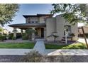 Inviting home with covered porch, green lawn and mature landscaping at 13687 N 151St Ln, Surprise, AZ 85379