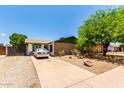 Well-kept home featuring desert landscaping, a clean driveway, and mature trees at 1509 E Verlea Dr, Tempe, AZ 85282