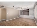 Spacious living room with wood floors, a ceiling fan, and custom built-in shelving at 1509 E Verlea Dr, Tempe, AZ 85282