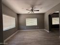 Bright living room with wood-look tile, a ceiling fan and neutral paint, providing a comfortable living space at 15334 W Acapulco Ln, Surprise, AZ 85379