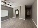 Open-concept living area with wood-look tile, a ceiling fan and an archway, offering a modern and spacious feel at 15334 W Acapulco Ln, Surprise, AZ 85379