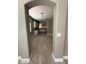 View through arched doorway into the kitchen area, showcasing wood-look flooring and neutral paint tones at 15334 W Acapulco Ln, Surprise, AZ 85379