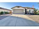 Attractive home featuring a desert landscape, an American flag, and a two-car garage at 16176 W Lisbon Ln, Surprise, AZ 85379