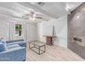 Bright living room featuring a modern fireplace, wood-look tile floors and white brick accents at 17401 N 16Th Ave, Phoenix, AZ 85023